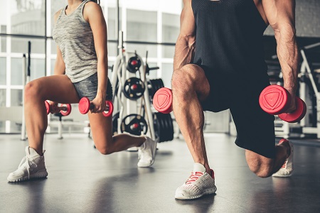 Two people working out with a weight in each hand